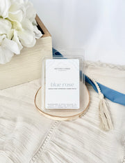 Scented Penn State themed wax melt labeled 'Blue Rose' on a textured surface with flowers and a blue ribbon.