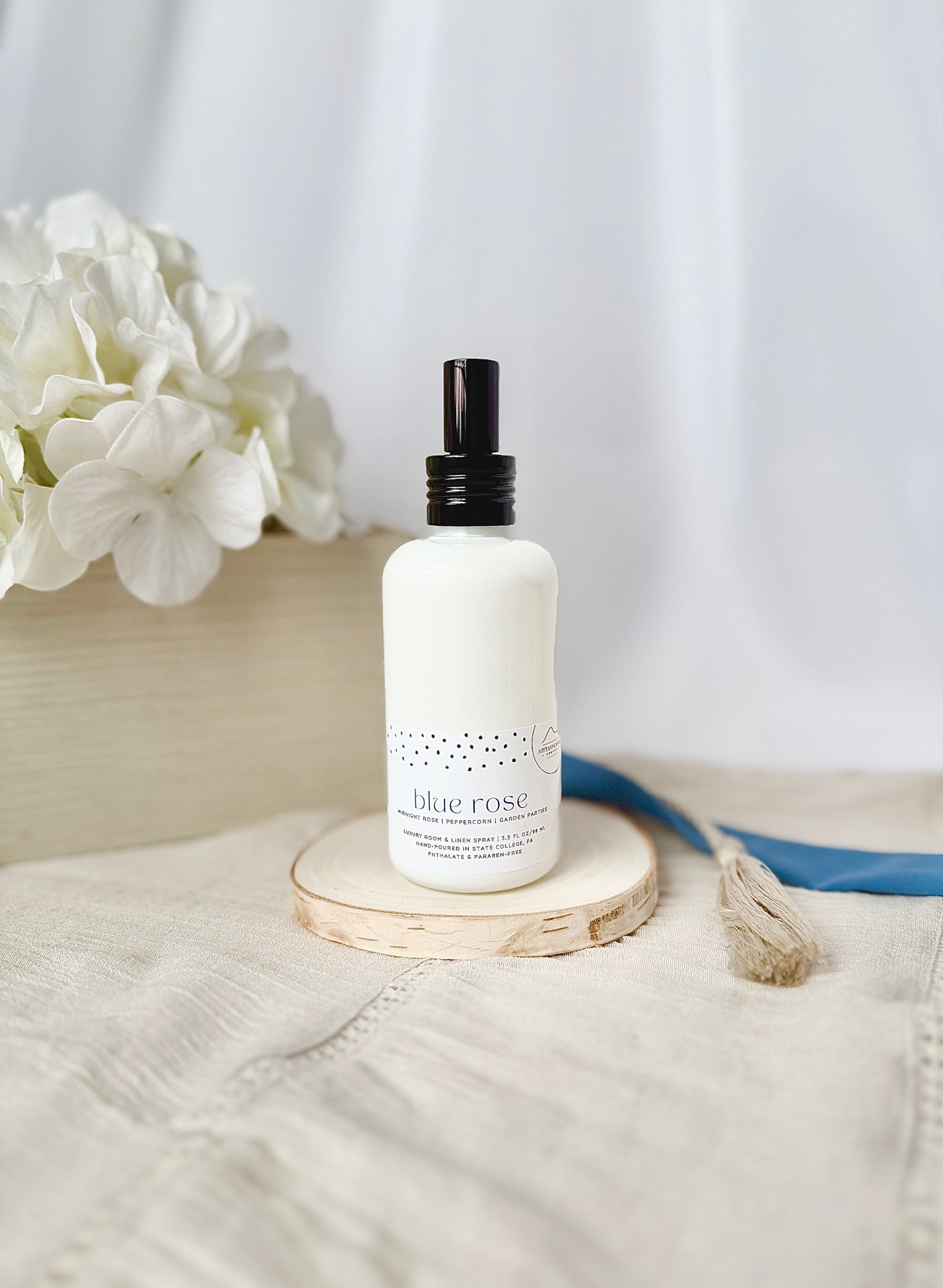 Penn State themed room and linen spray in a white bottle on a wooden coaster 