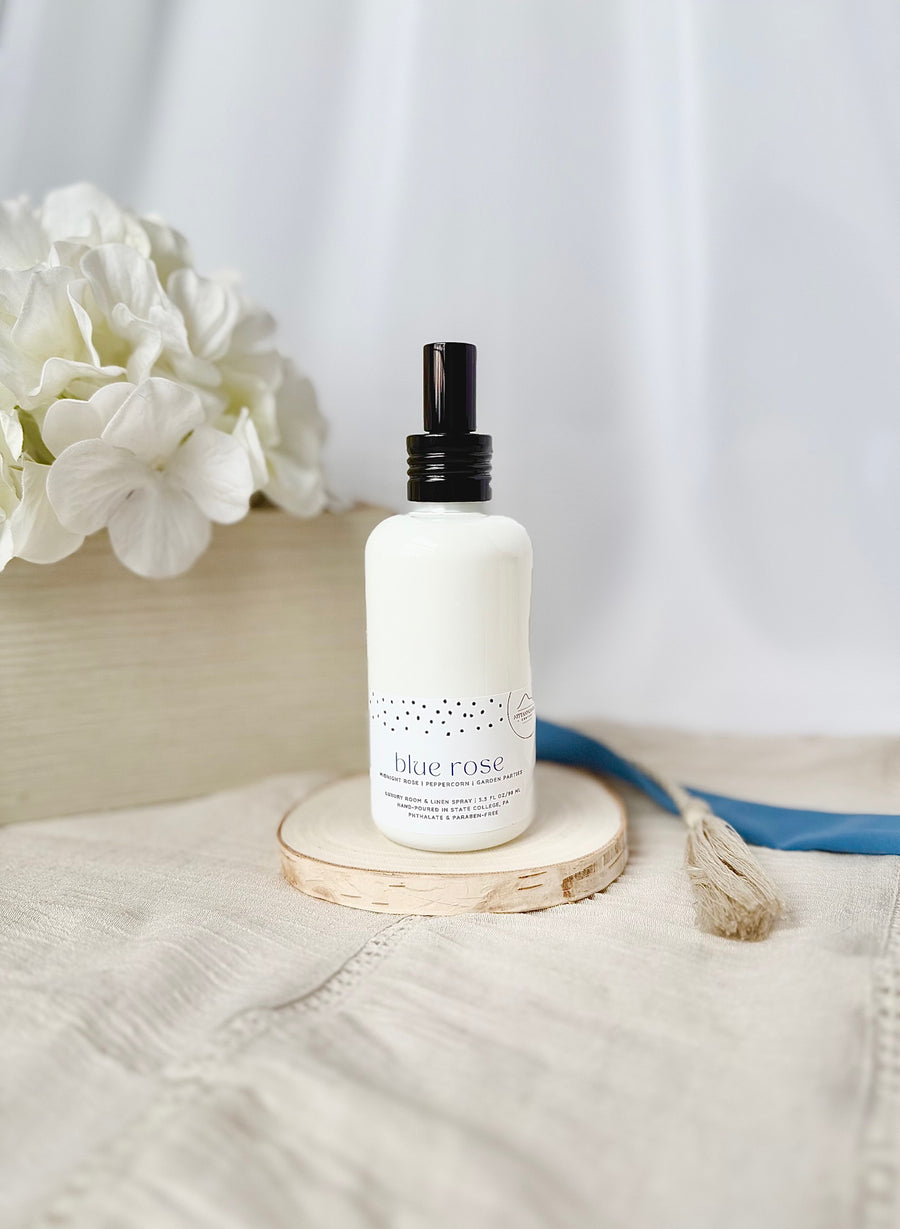 Penn State themed room and linen spray in a white bottle on a wooden coaster 