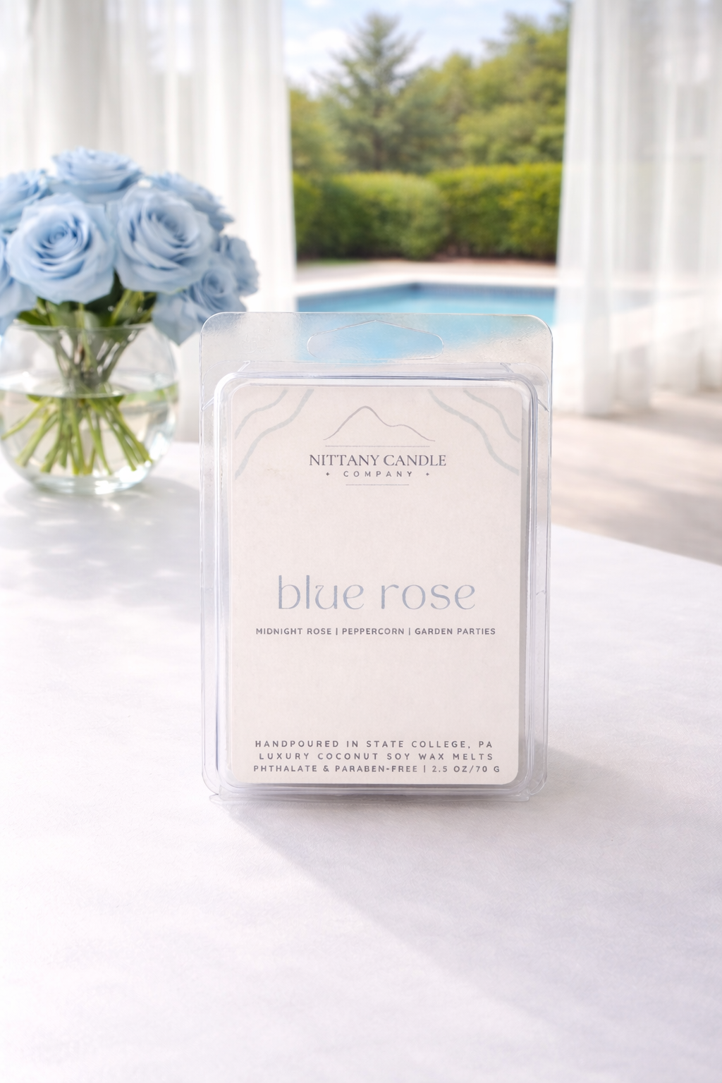Nittany Candle Company Penn State-themed blue rose wax melts on a table with a scenic background
