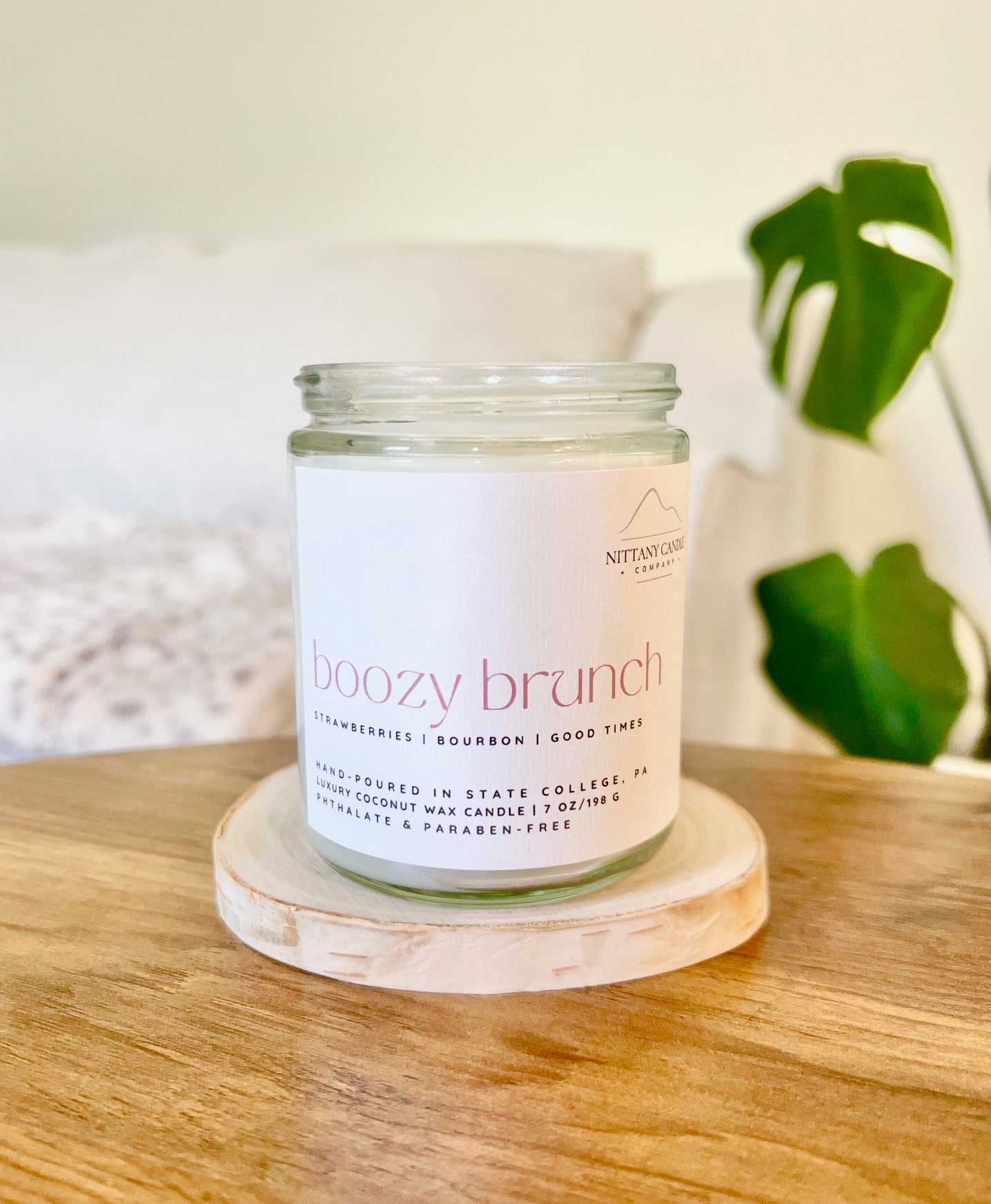Coconut wax candle in a jar labeled "Boozy Brunch"
