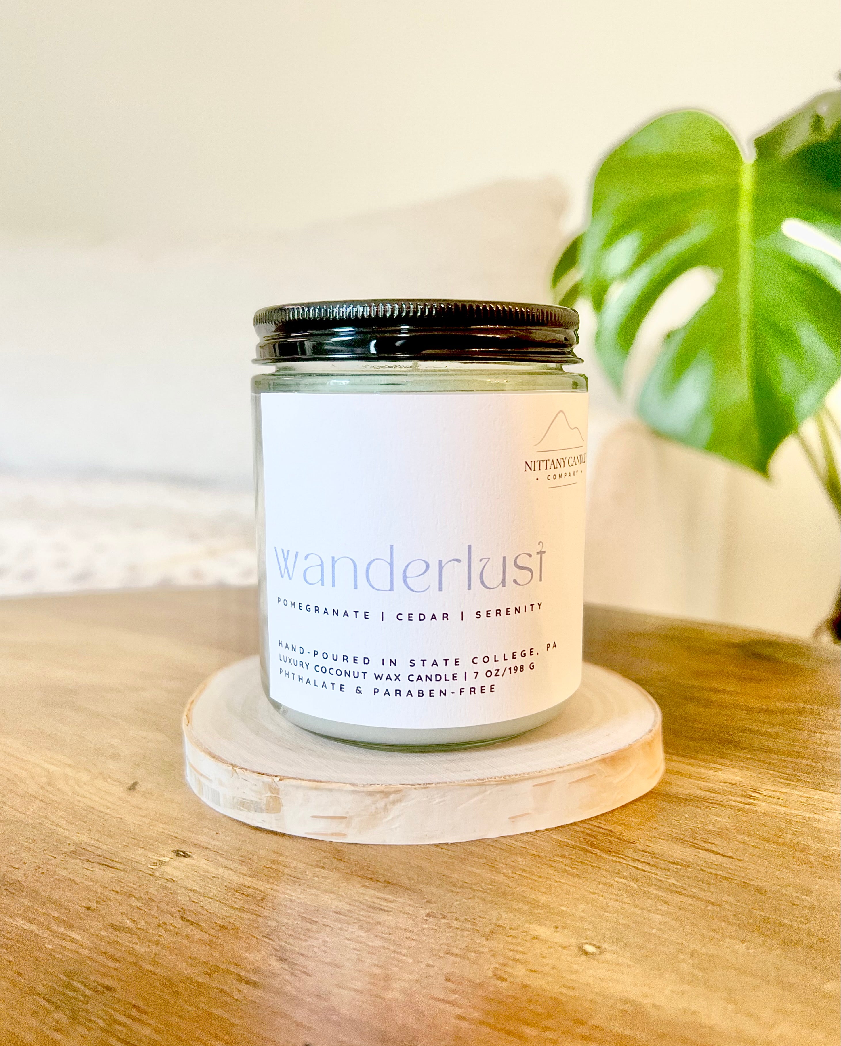 Coconut wax candle in a jar labeled "wanderlust" 