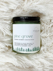 NITTANY Candle company candle labeled 'Pine Grove' on a fluffy white surface