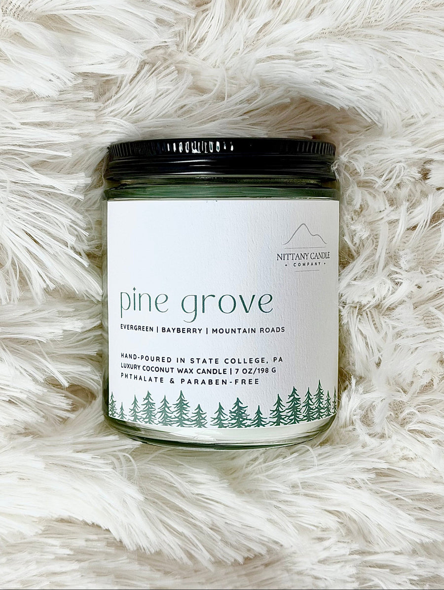 NITTANY Candle company candle labeled 'Pine Grove' on a fluffy white surface