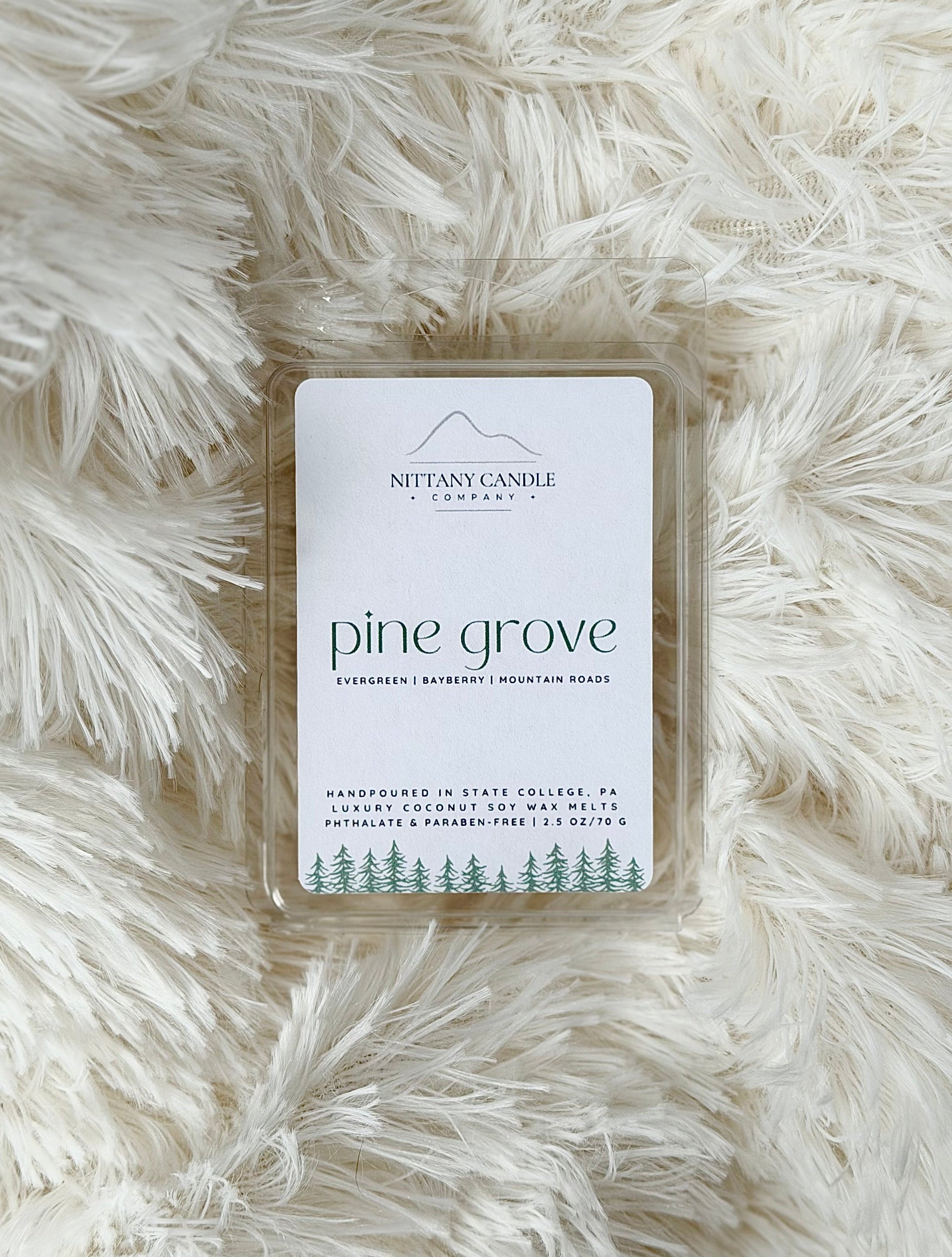 Wax melt packaging labeled 'pine grove' on a fluffy white surface