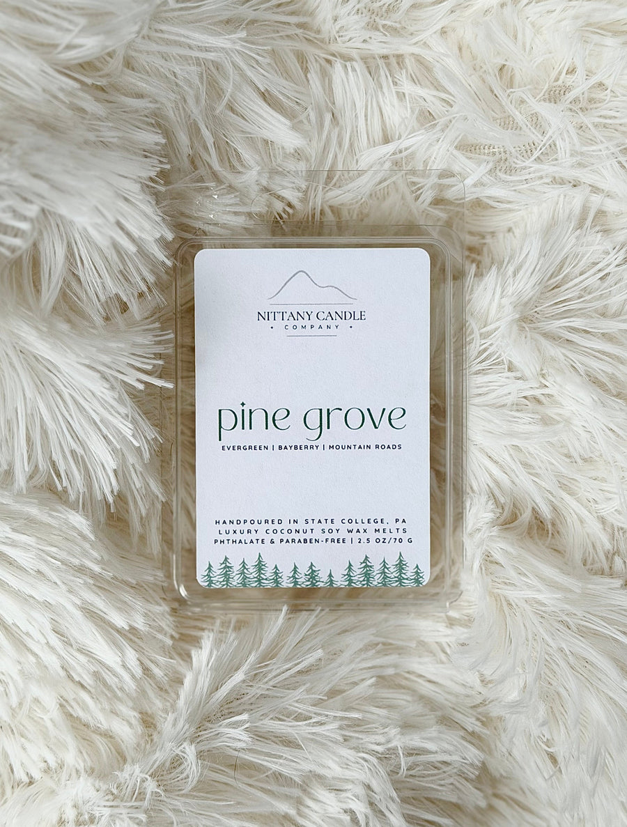 Wax melt packaging labeled 'pine grove' on a fluffy white surface