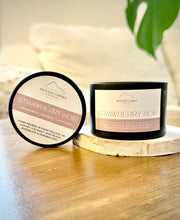Two candles labeled 'Strawberry Noir' by Nittany Candle Company on a wooden surface.