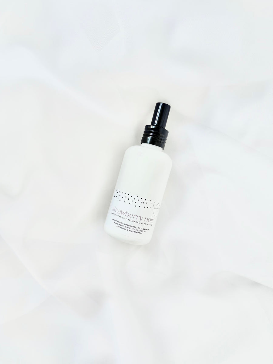 Nittany Candle Company linen spray bottle on white fabric background
