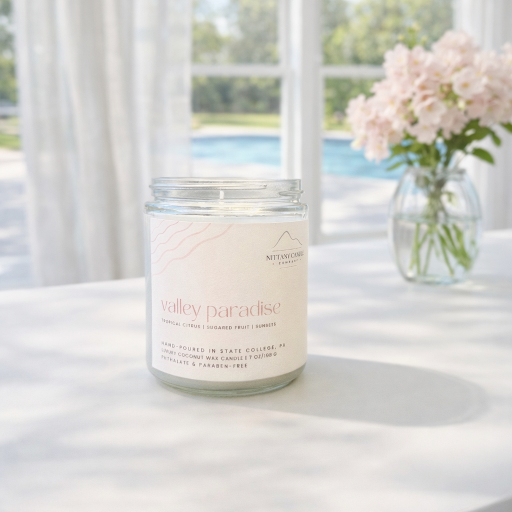 Candle labeled 'Valley Paradise' on a table with a scenic background